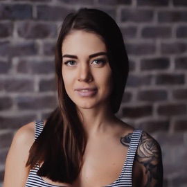 A young woman with tattoos and brown hair